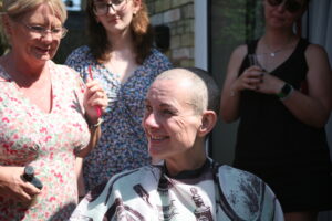 Kerry sits with friends and family behind her after her head shave