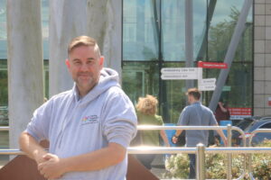 Steve stands outside Peterborough Hospital. 